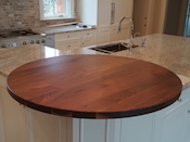 Walnut flat grain wood countertop, 48” diameter circle , ¼“ roundover edge, permanent finish. Designed by Arcadia Homes. Installed in Concord, North Carolina.